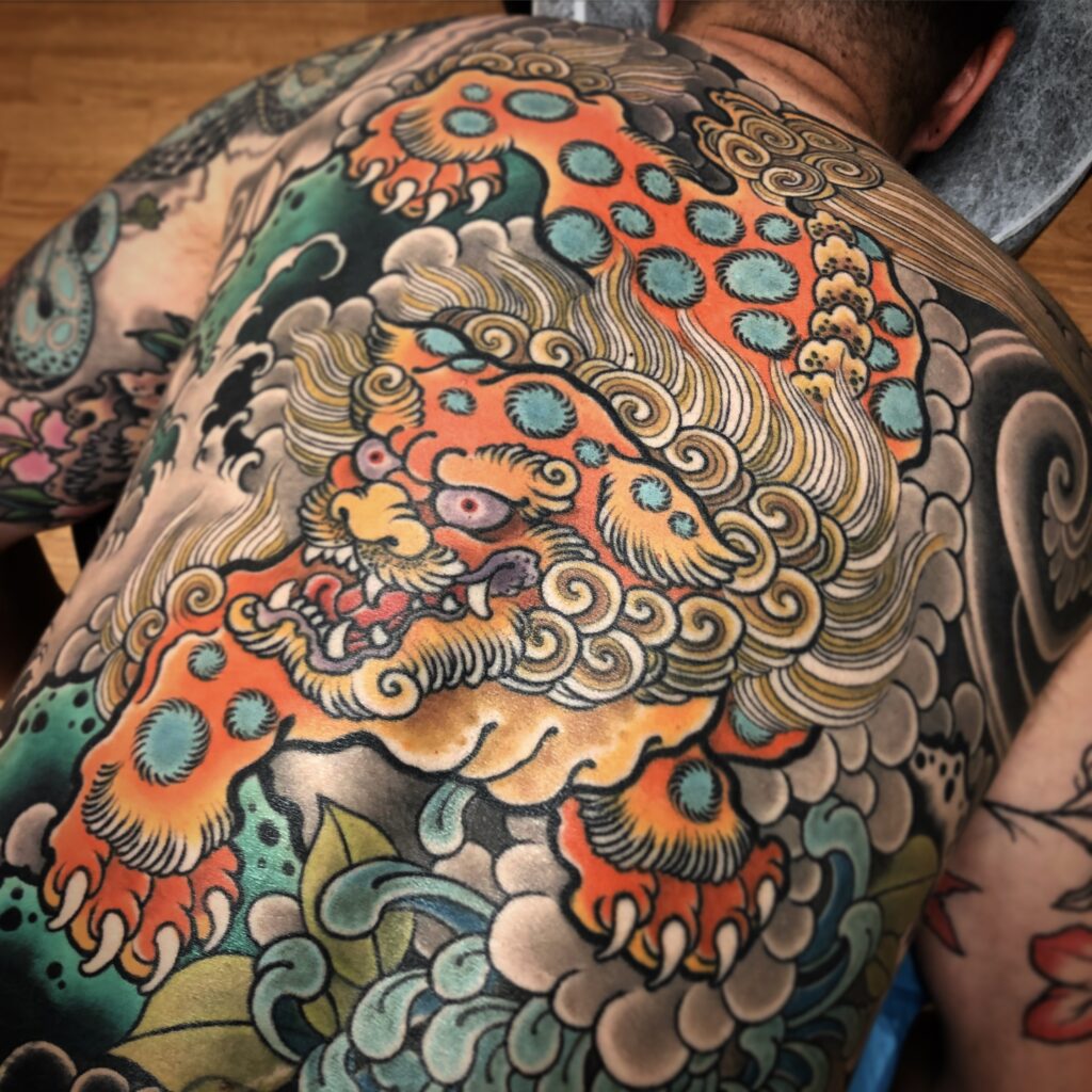 Japanese style back piece tattoo foo dog chrysanthemum bright color
